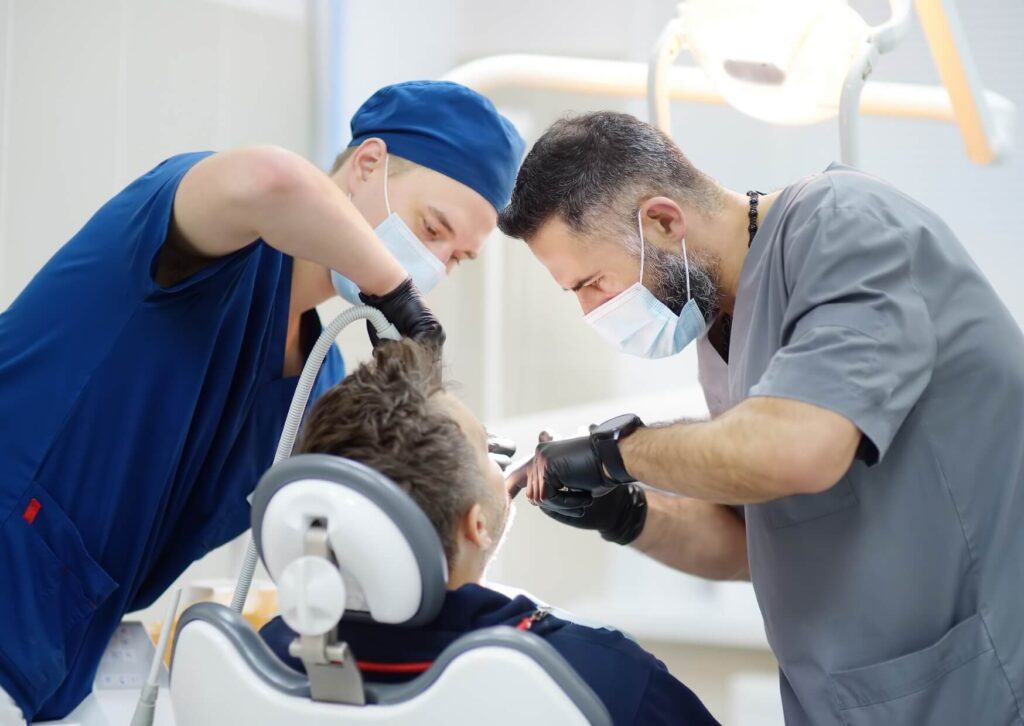 Dentists performing a dental implant removal procedure to treat a failed or damaged implant.